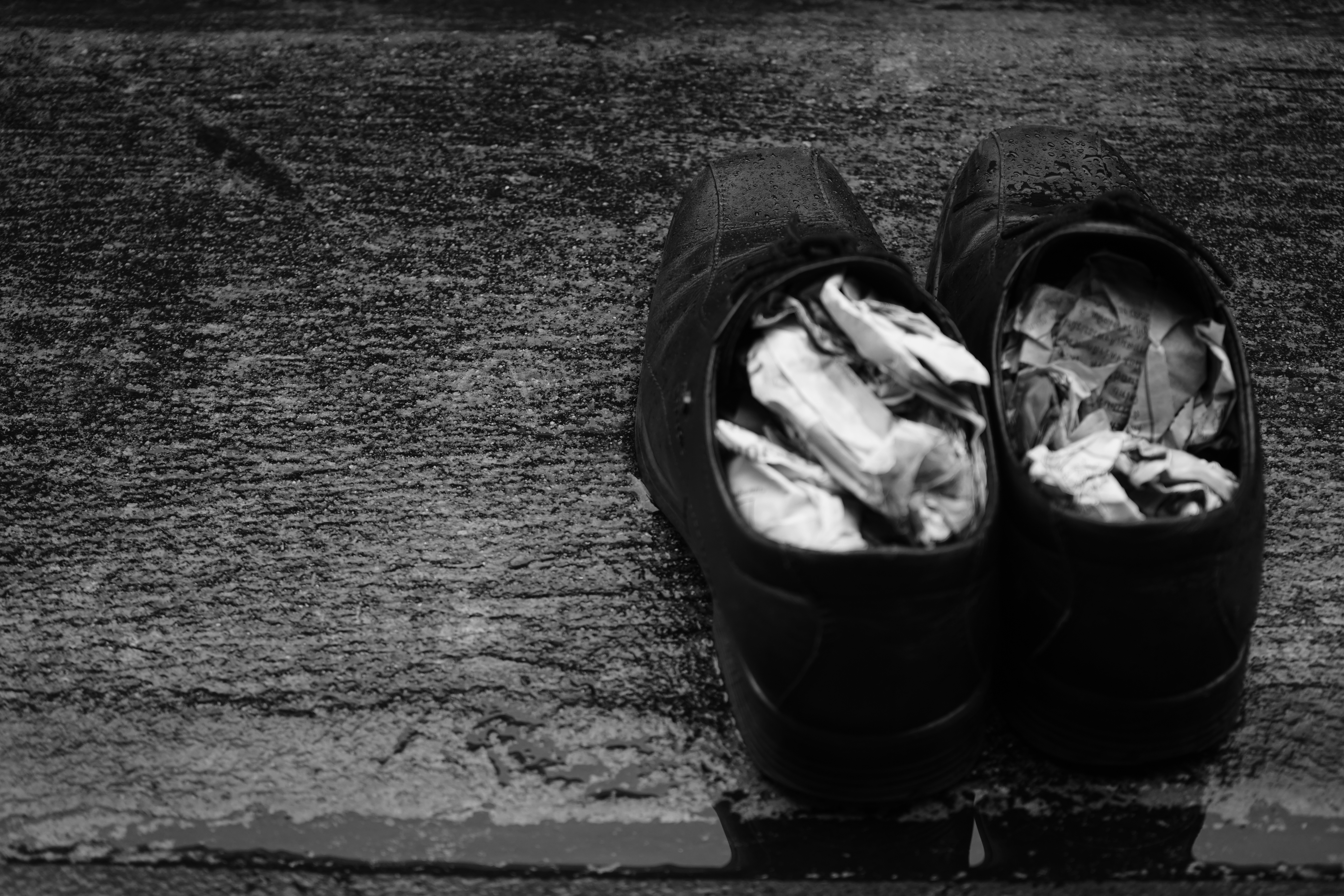 Stuffing wet shoes with newspaper